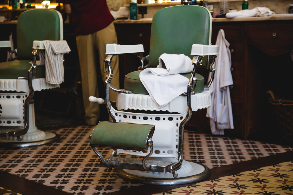 pair of green and white chairs in barbershop
