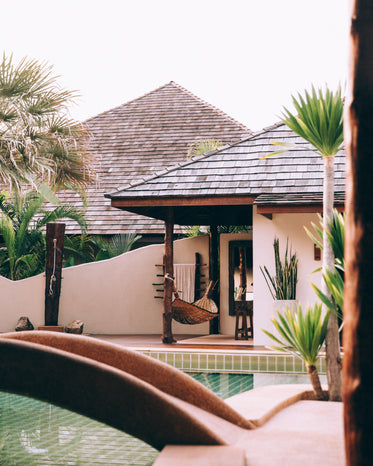 palm trees beyond poolside hammock