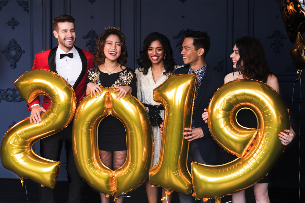 partygoers holding 2019 helium balloons