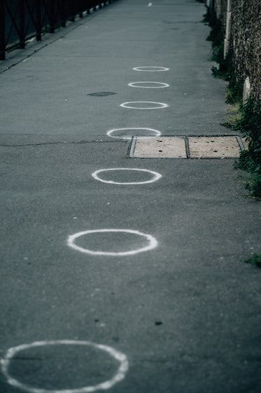 paved sidewalk with white painted circles