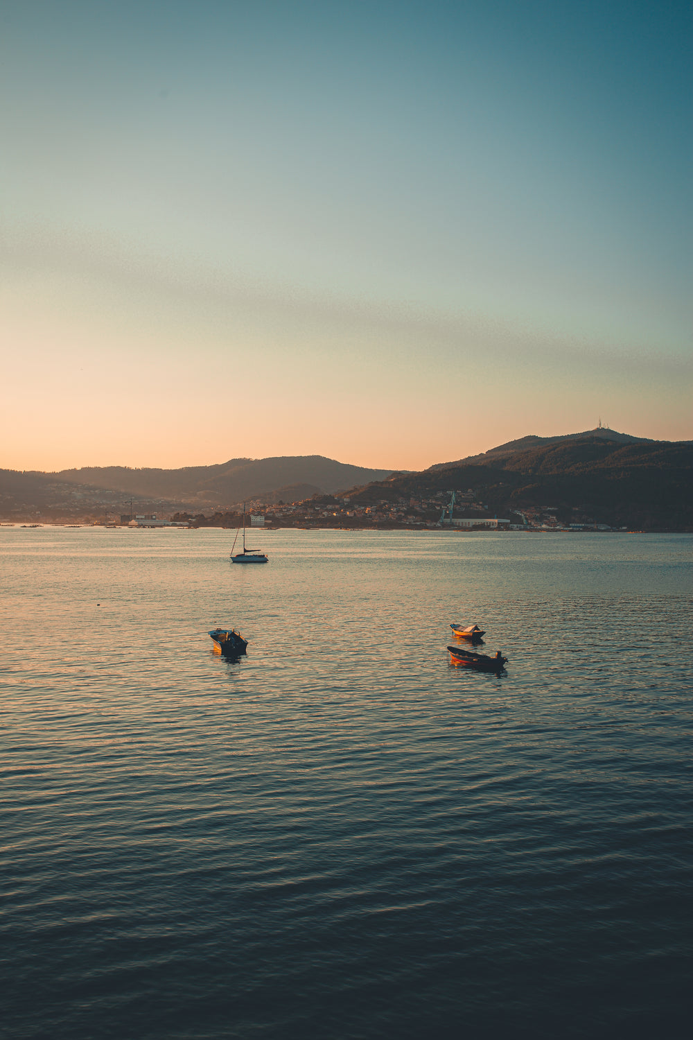 peaceful boats float on the water at sunset