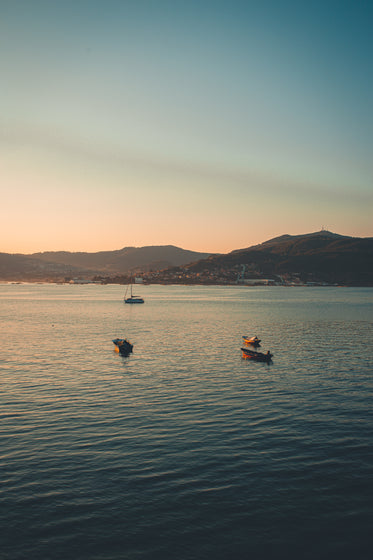 peaceful boats float on the water at sunset