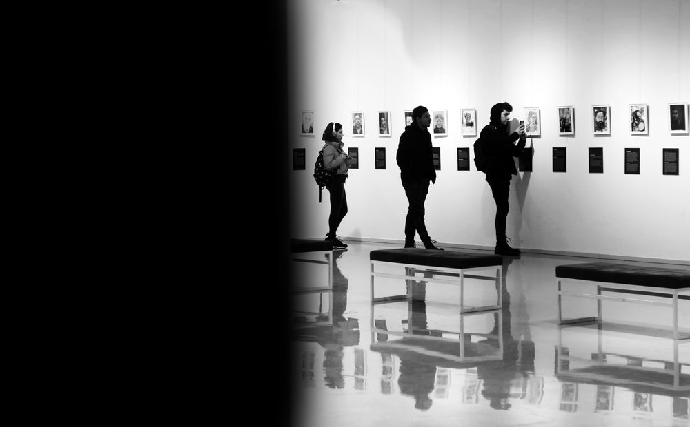 people at an art gallery facing the work