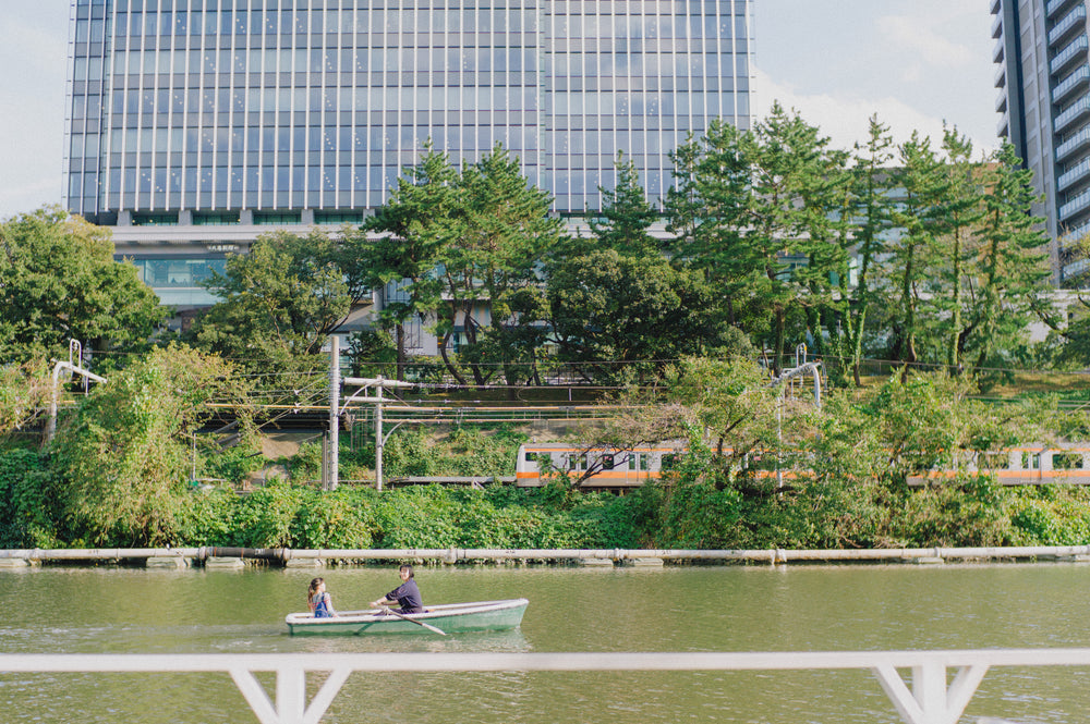 people enjoy rowing a boat on a river in a city