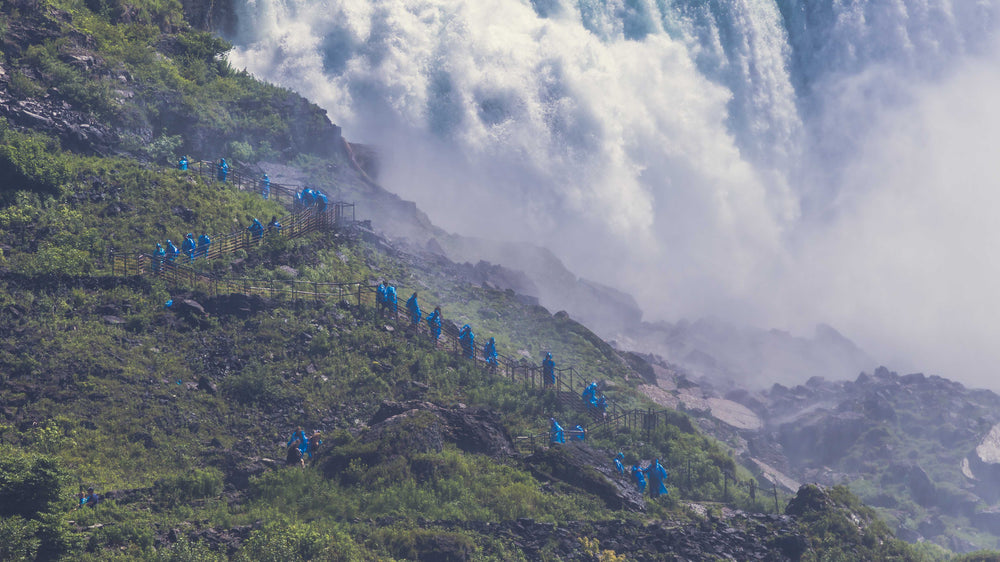 people hiking by waterfall