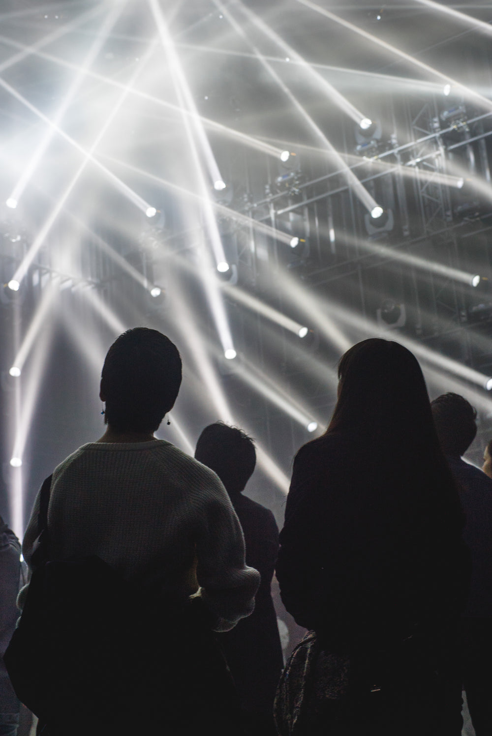 people looking at light beams from the walls