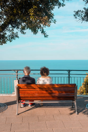 people sit on red bench and admire the view