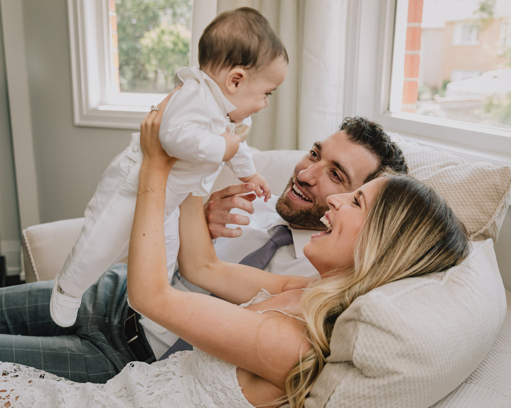 people smile at a small baby the woman is holding up