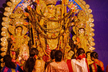 people stand with statue of durga maa