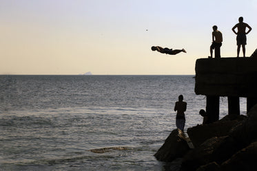 people standing on a dock near open water