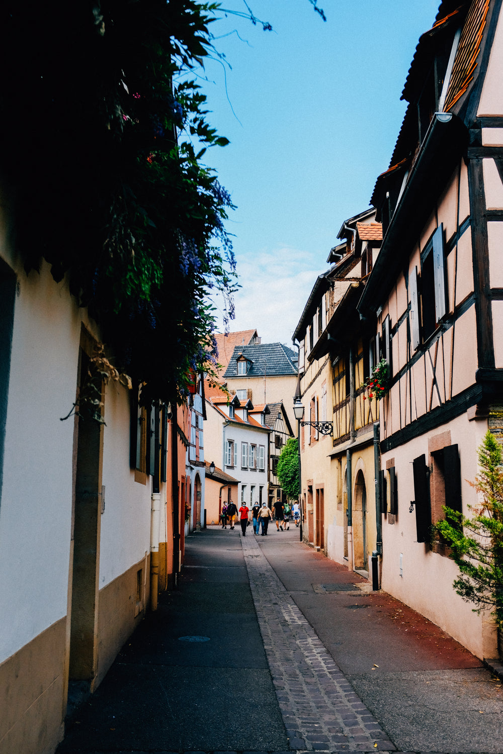 people walk through cobbled street in summer