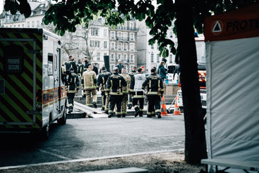 people wearing ppe stand facing a tall building