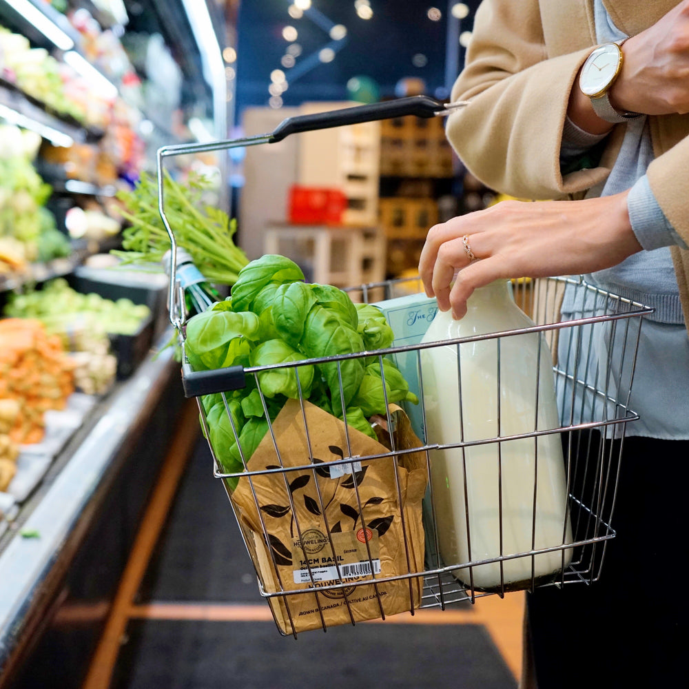 person adds milk to their shopping basket