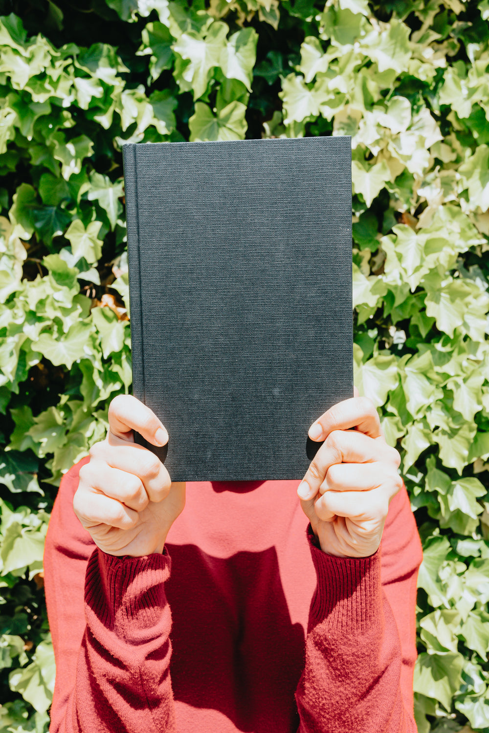 person and book held in front of their face