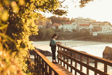 person bathed in golden light stands and reads a book