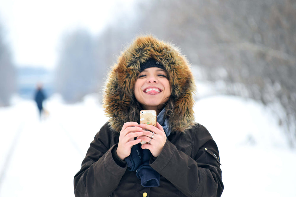 person bundled for winter sticks out tongue