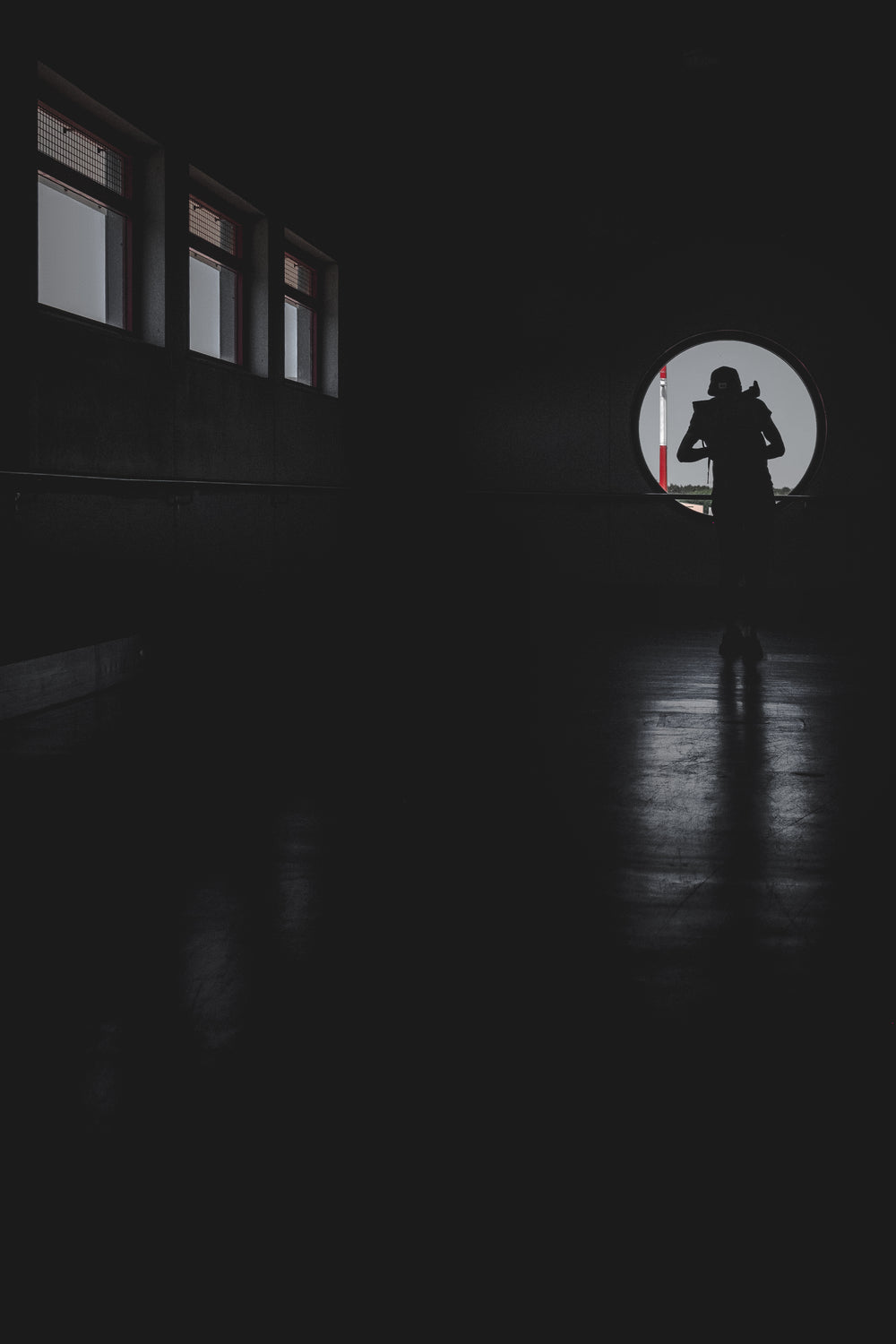 person cast in shadows looking from a window