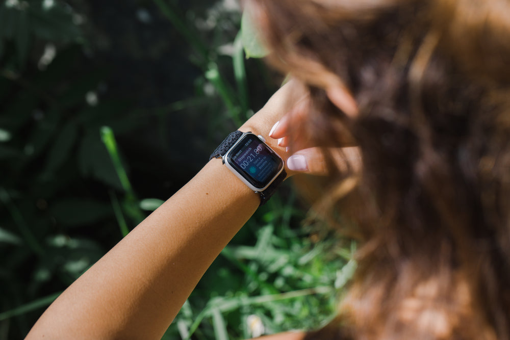 person checks their smartwatch outdoors