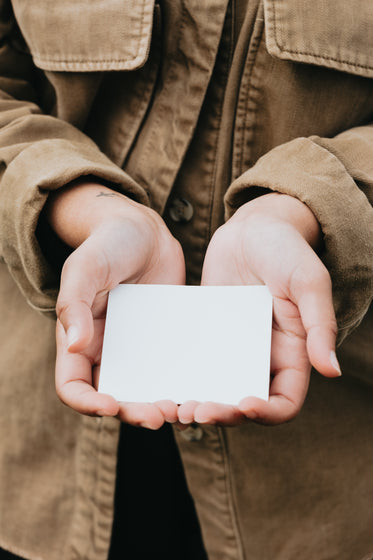 person cups a blank piece of white paper in hands