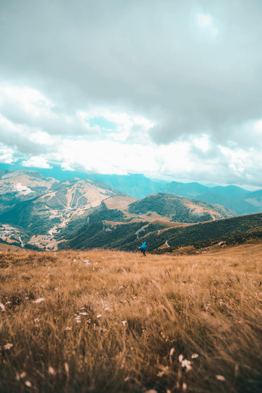 person dances in brown grassy hillside