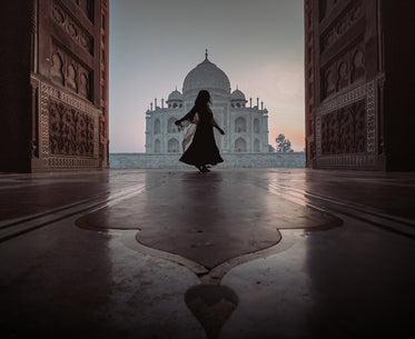 person dances in door way with a view of the taj mahal