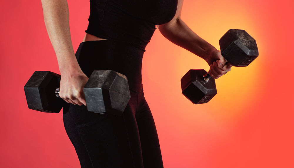 person dressed in black holds two weights in each hand