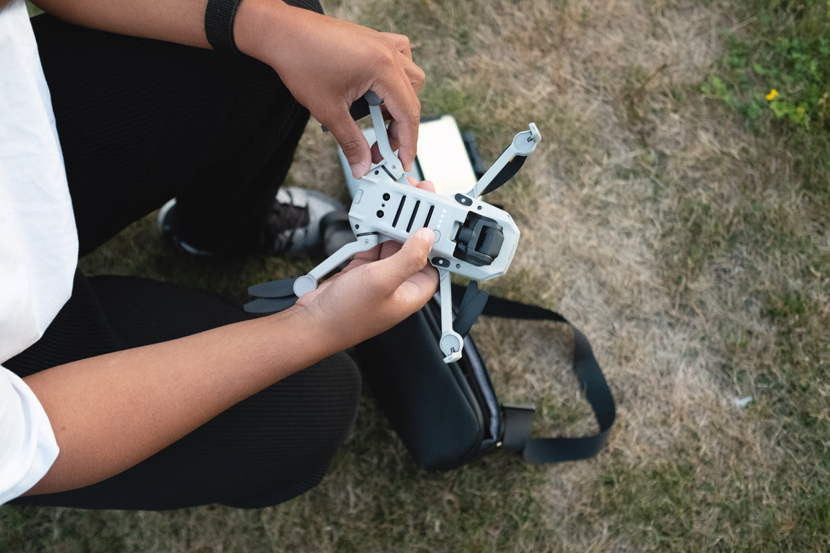person gets a drone ready for flight outdoors