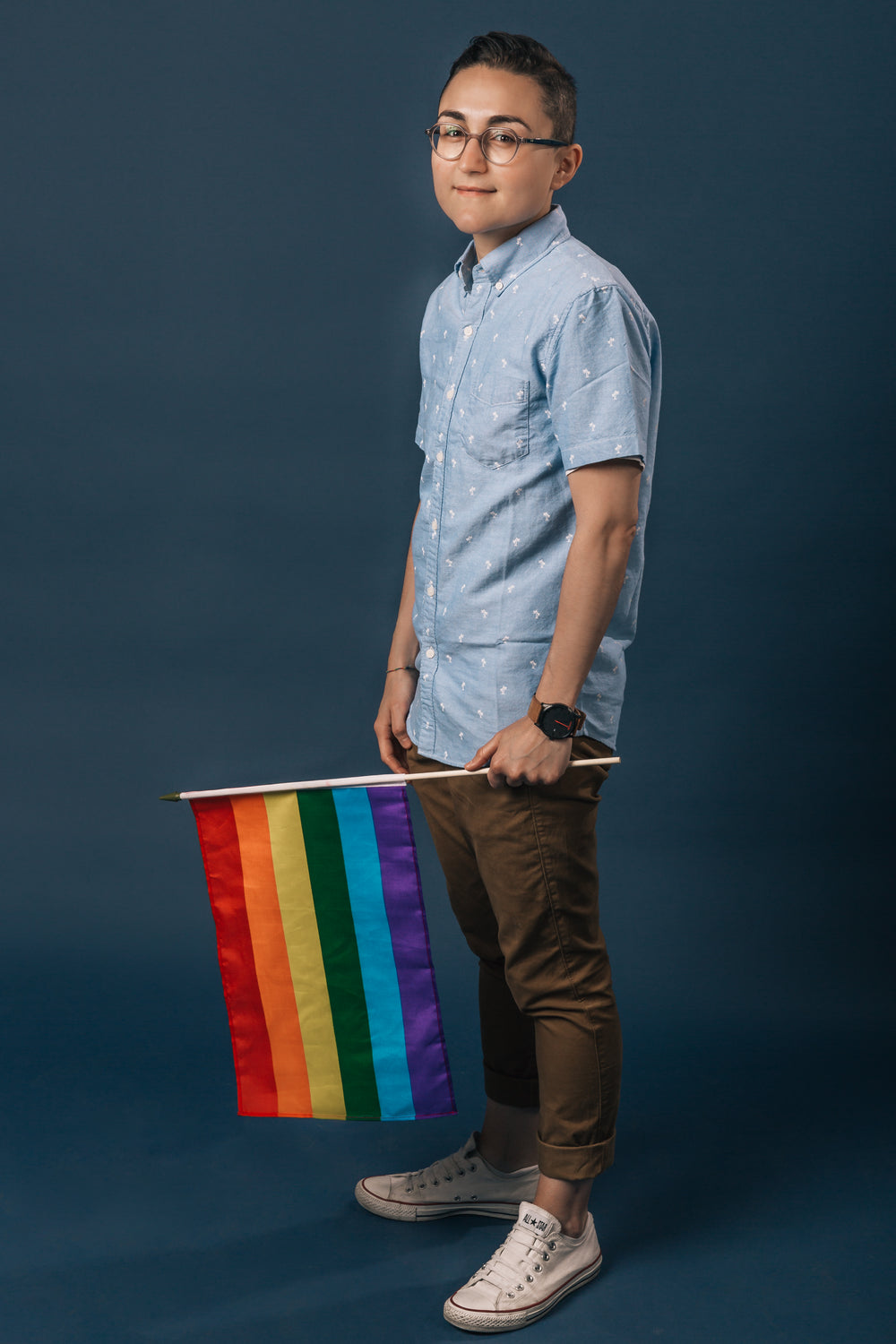 person holding small pride flag portrait