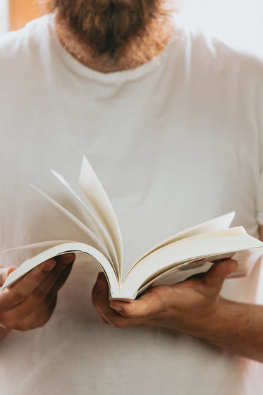 person holds a book and flips through the pages