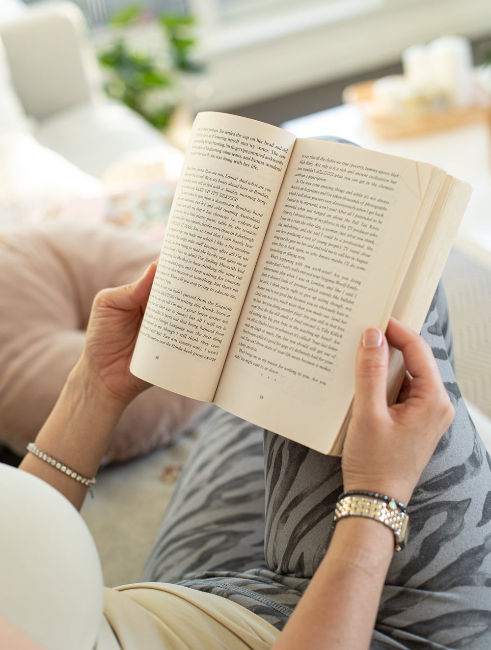 person holds a book open against their legs