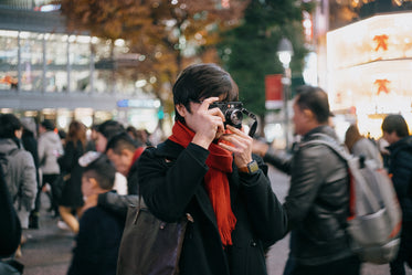 person holds a camera up and takes a picture outdoors