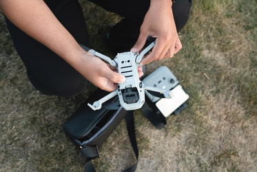 person holds a drone outdoors and gets it ready to fly