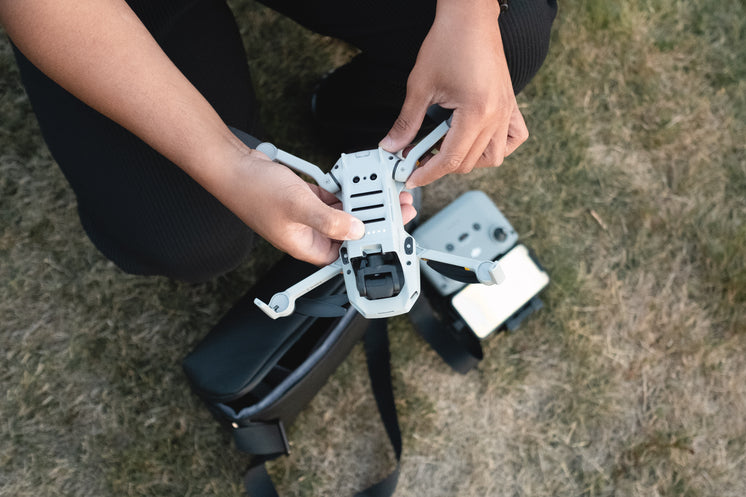 Person Holds A Drone Outdoors And Gets It Ready To Fly