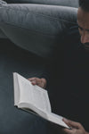 person holds a novel open and reads
