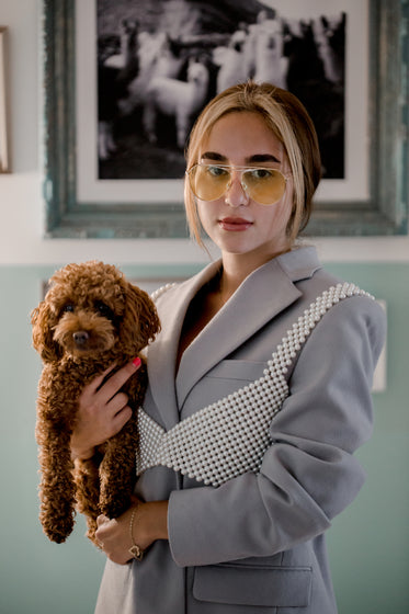 person holds a puppy and looks at the camera