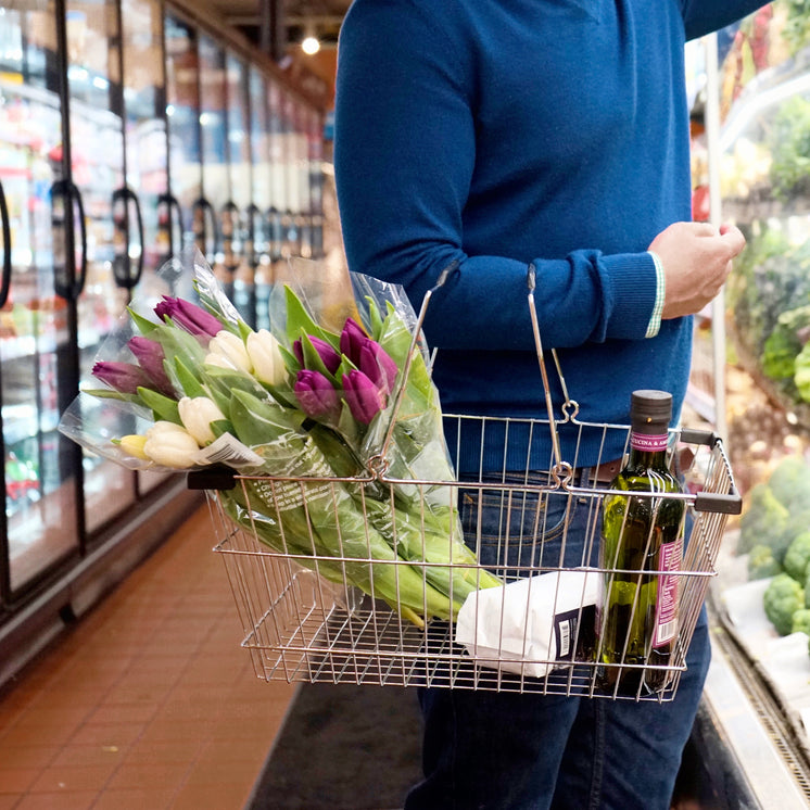 Person Holds A Silver Shopping Basket Carrying Tulips