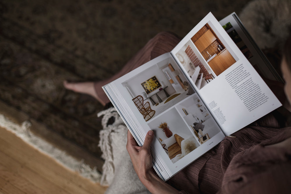 person holds an interior design book on their lap