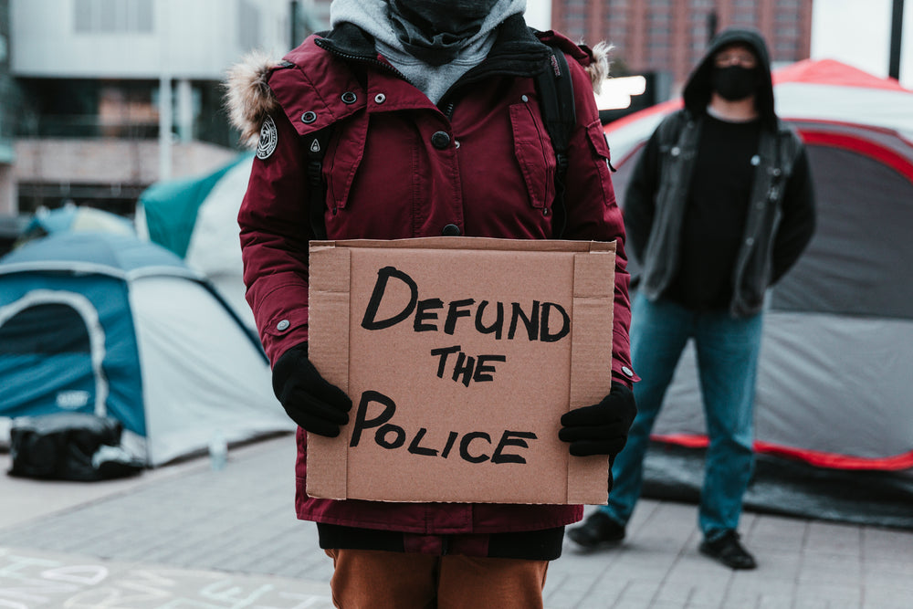 person holds cardboard sign in protest