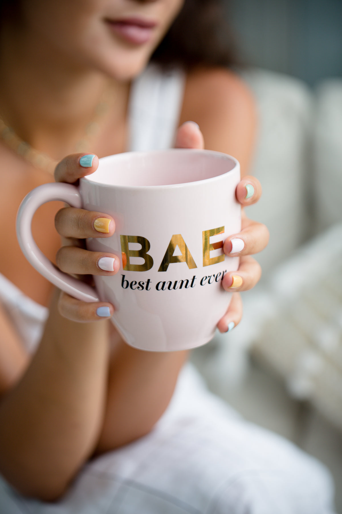 person holds out a mug that says best aunt ever