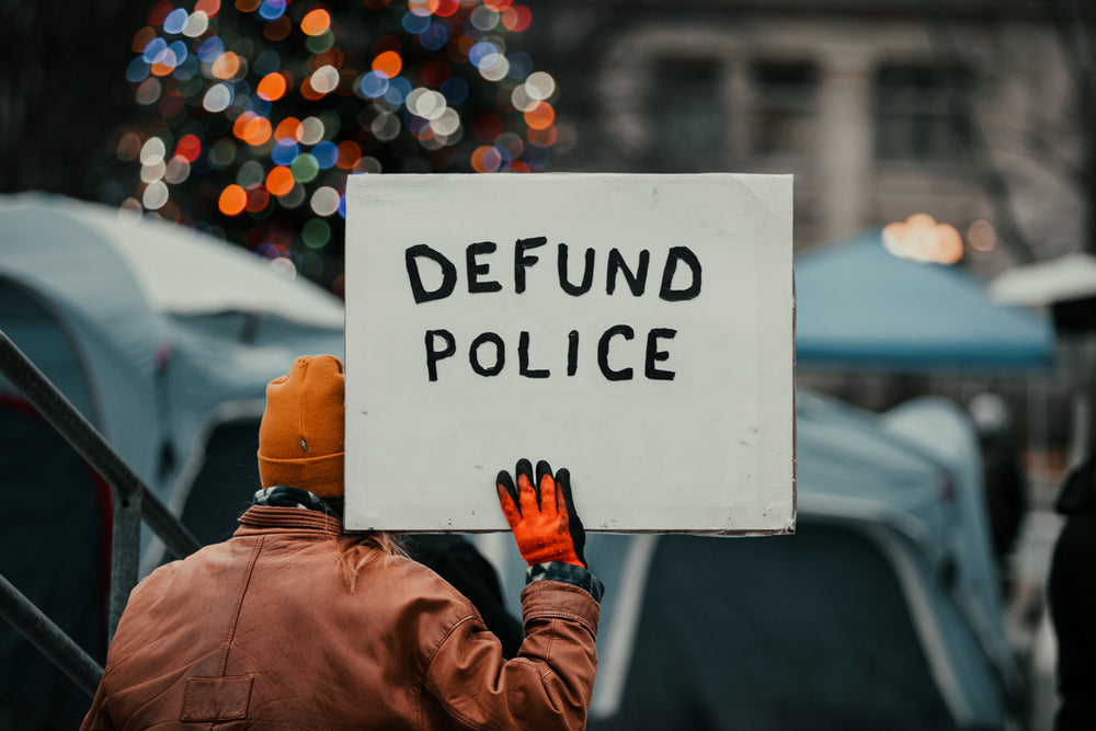 person holds sign over head in protest