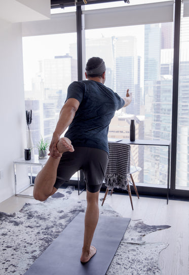 person holds their foot behind them in a yoga pose