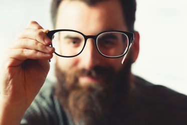 person holds their glasses in front of them