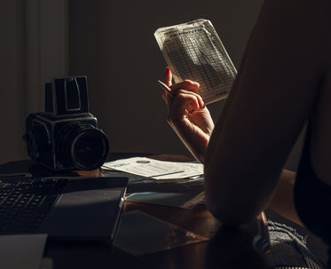 person holds up paper sitting at a desk