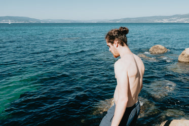 person in a bathing suit walks towards the water