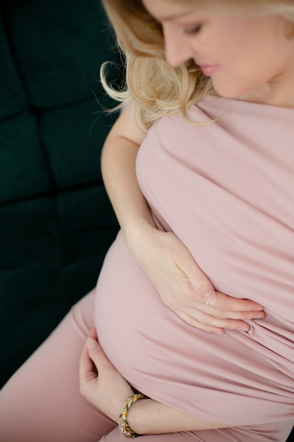 person in all pink smiles and holds her belly