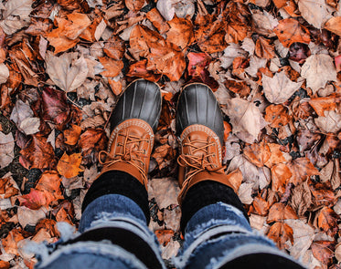 person in boots stand on crunchy fall leaves