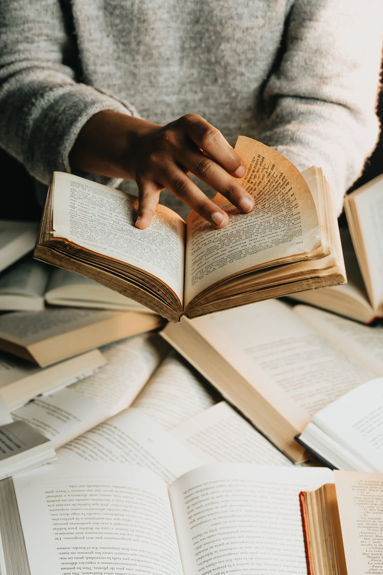 person-in-grey-sweater-holds-a-book-open