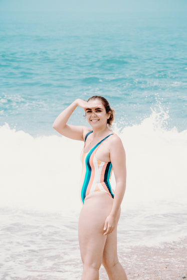 person in one piece swimsuit smiles at the camera