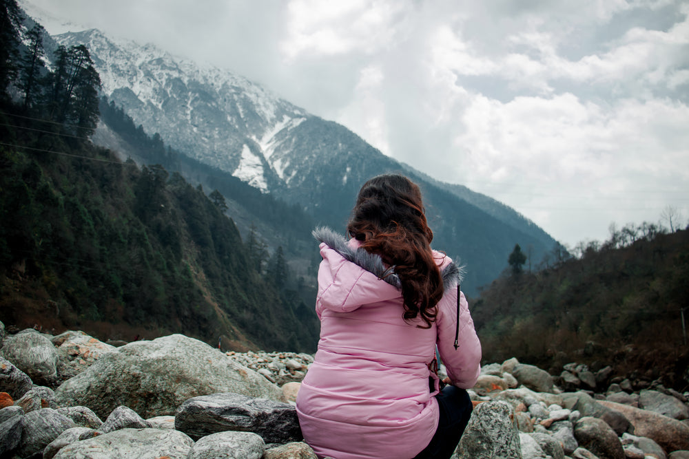 person in pink looks out to a mountain view