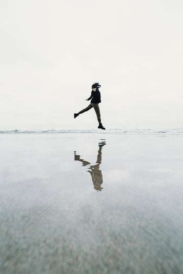 person jumping on beach creating a floating illusion